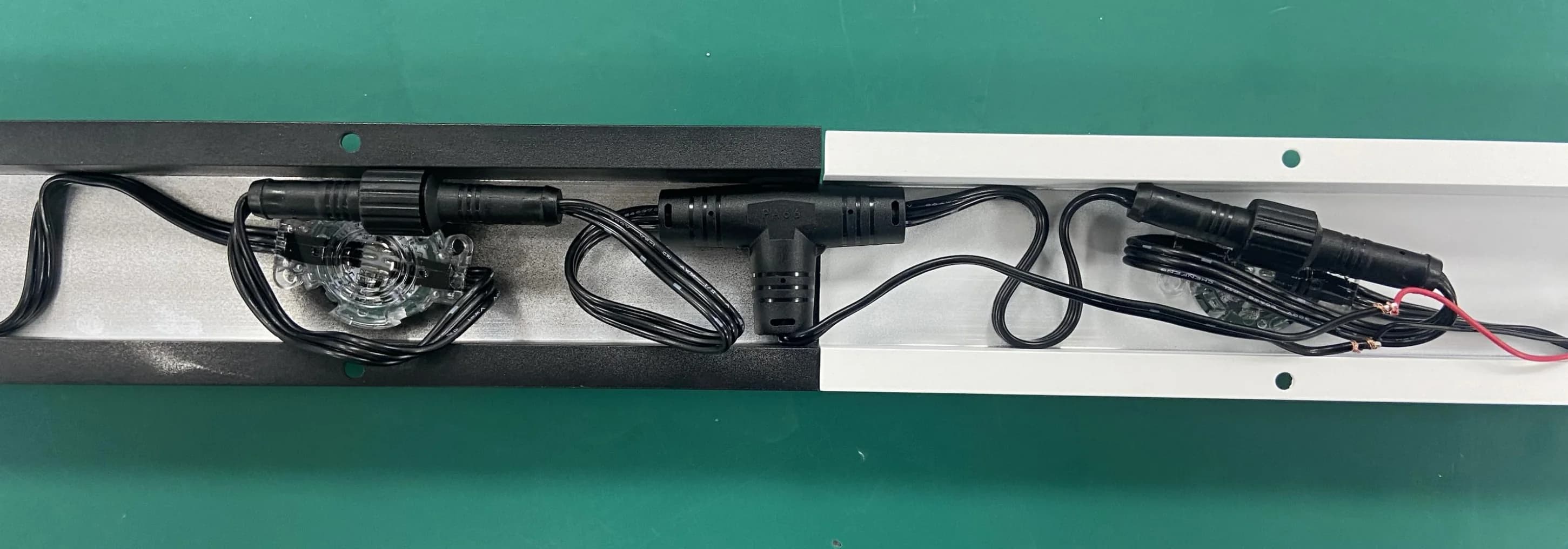T connector and wiring organized inside adjoining black and white mounting tracks